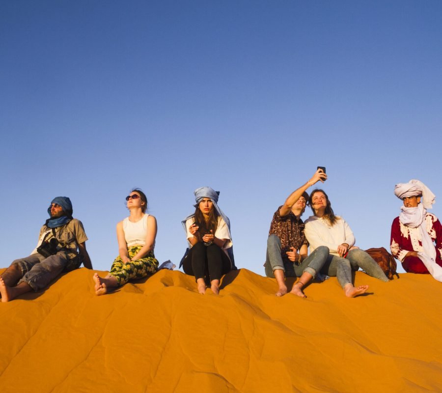 group-people-sitting-top-dune